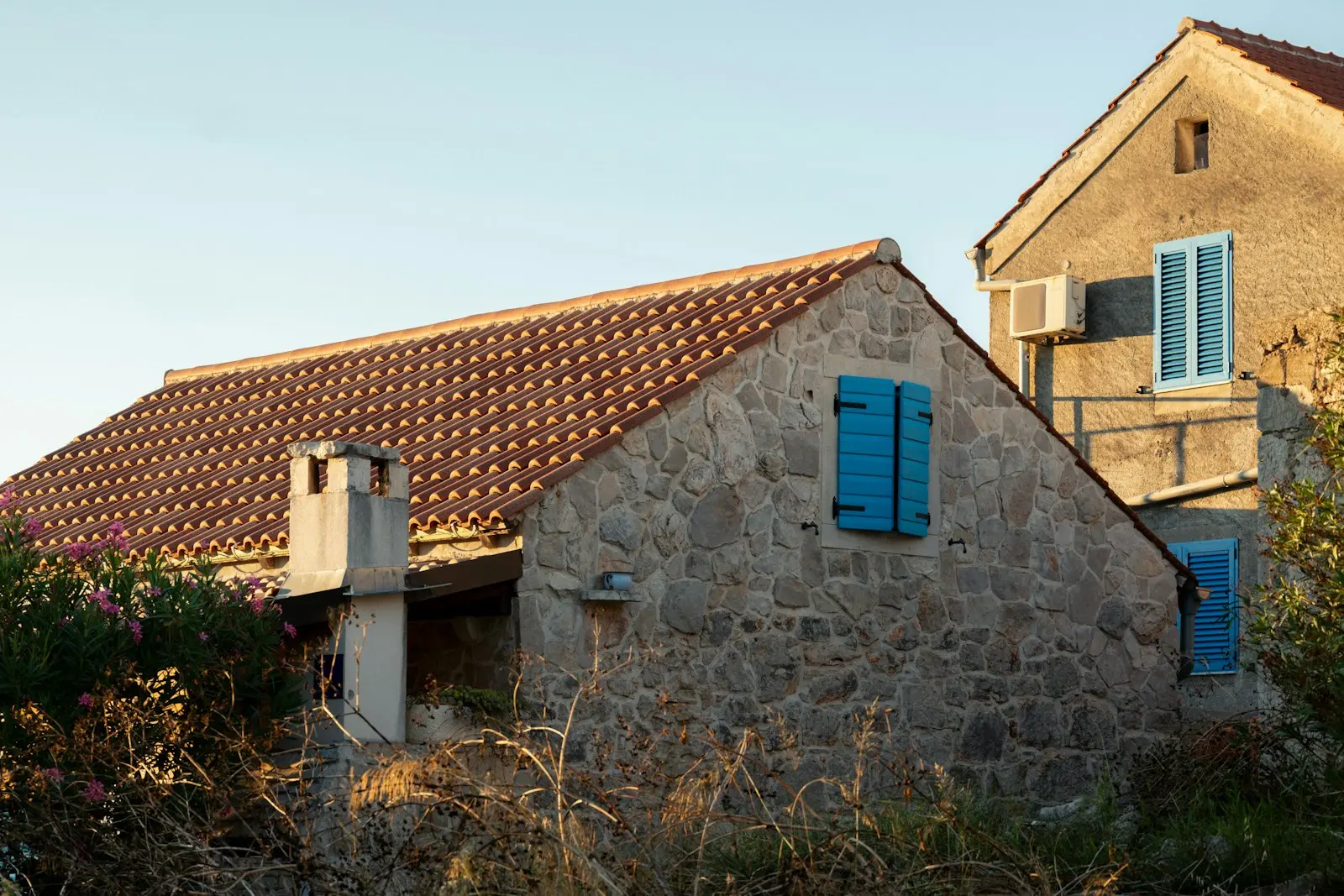 Maison en pierre méditerranéenne coiffée d'une toiture en tuiles terre cuite